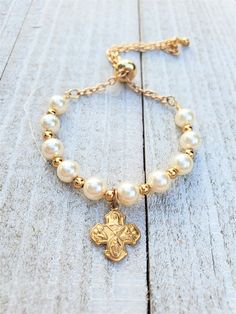 "baptism bracelet for boy, baptism bracelet for girl, bracelet for Catholic baby baptism, Catholic baby gift, Goddaughter gift, Christening bracelet, gift from Godmother Elegant little baptism bracelet. Bracelet is made from 6 mm Swarovski Pearls in the color Cream. The small gold beads in between are 4 mm 14 K filled beads. All of the beads are tarnish resistant. They will not tarnish, change colors, rust or irritate skin. This is a bracelet that will last and remain beautiful for years to come Adjustable Gold Rosary Bracelet For Baptism, Adjustable Cross Bracelets For Baptism, Adjustable Cross Rosary Bracelet For First Communion, Spiritual Cross Bracelets For Baptism, Adjustable Personalized Pearl Bracelet For Baptism, Adjustable Cross Bracelet For First Communion, Adjustable Cross Bracelets For First Communion, Personalized Adjustable Rosary Bracelet For Confirmation, Adjustable Hypoallergenic Rosary Bracelet For First Communion