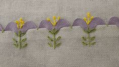 some yellow flowers are on the side of a piece of fabric that has been stitched together