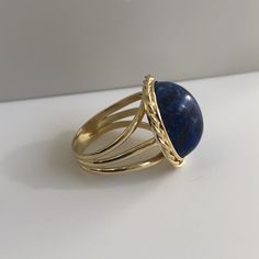 Lapis lazuli - richly blue and in excellent shape. This massive lapis is held in a beautiful vintage ring crafted in 18K yellow gold with beautiful braided bezel detail. The shank splits in three different bands tapering down to a single band at the bottom of 4.30mm This ring is currently a size 8.5 but can be sized down upon request. With any pre-owned/Vintage/Antique items, it is common to have some wear, As we inspect each piece of our jewelry, we make sure the wear and tear is acceptable wit Timeless Blue Oval Cabochon Jewelry, Timeless Blue Gemstone Signet Ring, Elegant Blue Oval Cabochon Signet Ring, Blue Cabochon Ring In Fine Jewelry Style, Fine Jewelry Blue Cabochon Ring, Blue Cabochon Fine Jewelry Ring, Blue Cabochon Sapphire Ring In 14k Gold, Elegant Blue Gemstone Signet Ring, Elegant Blue Sapphire Signet Ring