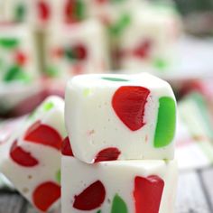 white and red dices with green leaves on them sitting on a wooden table next to candy canes