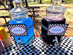 there are two jars on the table with different colored liquids in them and one is empty