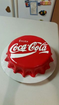 a coca - cola bottle cap sitting on top of a refrigerator