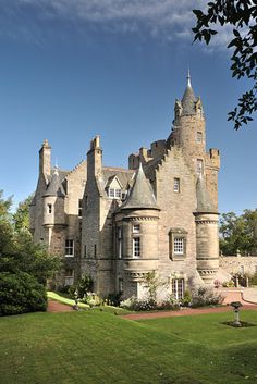 an old castle like building sitting on top of a lush green field