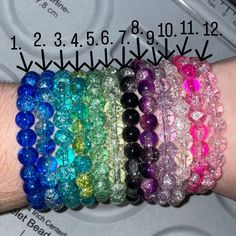 a person's arm with several bracelets on top of it and the numbers below them