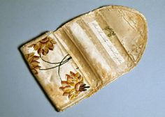 an old piece of cloth has been embroidered with flowers on it and is sitting on a blue surface