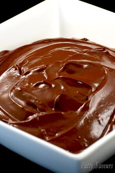 a square white bowl filled with chocolate frosting