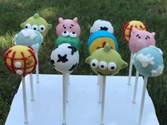 there are many cake pops on the stick in the shape of animals and pigs with different colors