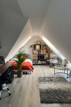 an attic bedroom with wood flooring and white walls, along with a large rug on the floor