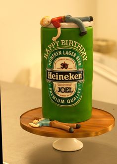 a birthday cake made to look like a can of heineken beer on a table