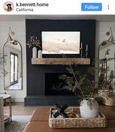 the living room is decorated in black and white with greenery on the coffee table