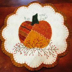 a white plate topped with an orange pumpkin on top of a wooden table