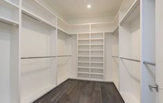 an empty walk - in closet with white walls and shelving units on the floor