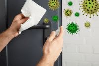 a person is cleaning the refrigerator door with a cloth and some green germs on it