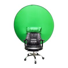 an office chair sitting in front of a giant green ball with a pillow on it