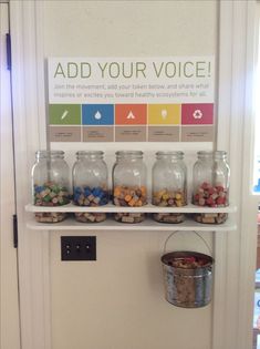 there are several jars on the wall with food in them and an ad for your voice