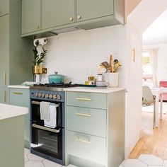 a kitchen with green cabinets and an oven