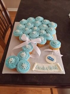 a table topped with cupcakes covered in blue frosting and white icing