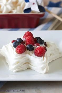 a dessert with berries and whipped cream on a plate