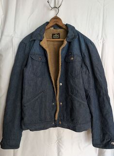 "1970s fleece-lined denim men's vintage jacket by Blue Bell Maverick Fuzzy tan fleece lining in the body and a satin quilted lining in the arms 23\" chest (measured armpit to armpit) 19.5\" hips 25\" length (measured shoulder to bottom seam) 19\" sleeve length (measured armpit to cuff) 1970s vintage medium wash denim jacket with 5 snap button closure in front Snap buttons on 2 chest pockets, snap buttons on wrists Adjustable sizing buttons on back waist In great condition, no fraying on the outer area of the cuffs or elbows, no discoloration, no rips, tears, or stains on the outside of the jacket There is a small tear in the quilted inner lining of each wrist (see photo) *The Pearl Vintage Shop Disclaimer* Please note: This is a previously-used vintage clothing item. Be aware that the item Vintage Denim Outerwear For Winter, Vintage Winter Denim Outerwear, Rugged Denim Outerwear For Winter, Vintage Denim Jacket With Corduroy Collar For Winter, Vintage Cotton Denim Jacket For Outdoor, Vintage Cotton Denim Jacket For Winter, Vintage Cotton Denim Jacket With Corduroy Collar, Fleece Lined Denim Jacket, Satin Quilt