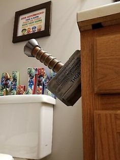 a bathroom with toothbrushes and other items on the toilet bowl lid, next to a wooden cabinet