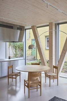 a dining room table and chairs in front of large windows