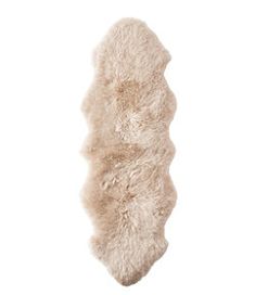 a white sheepskin rug is shown against a white background with the fur on it's side