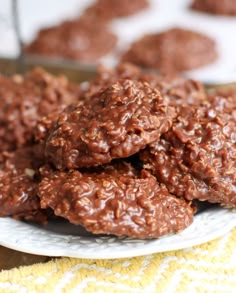 chocolate cookies stacked on top of each other on a white plate with yellow towels in the background