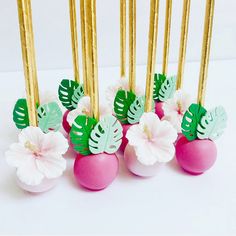 some pink and green decorated eggs with gold sticks