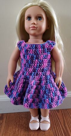 a doll with blonde hair wearing a purple and blue crochet knitted dress