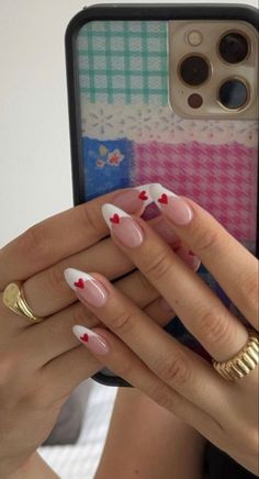 a woman's hands with pink and white manicures holding an iphone case