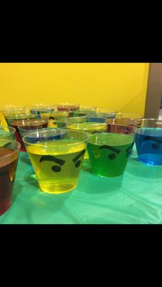 there are many cups with different colored liquids in them and one has an angry face on it