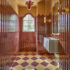 an ornate bathroom with red and gold tiles on the walls, flooring and windows