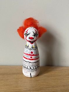 a wooden doll with red hair on top of a table