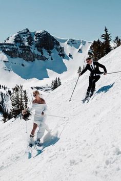 two people skiing down a snow covered mountain