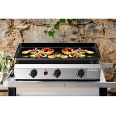 an outdoor grill with food cooking on it's burners and side burners