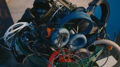 a pile of assorted electronic equipment sitting on top of a table next to a blue wall