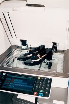 a pair of shoes sitting on top of a printer