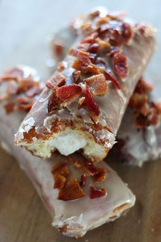 bacon and cream filled doughnuts on a wooden table with one broken in half