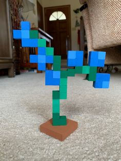 Minecraft blue orchid flower made of small wooden blocks painted. Green stem with 6 blue flowers. Terracotta brown square base at the bottom. Minecraft Flower Out Of Blocks, Minecraft Blue Orchid Flower, Minecraft Block Painting, Small Diy Wood Gifts, Blue Orchids Minecraft, Wood Block Minecraft Flower, Minecraft Flower Cubes, Wood Block Pixel Art, Wooden Block Art Ideas