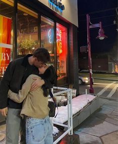 a man and woman kissing in front of a store