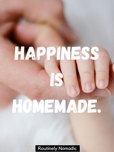 a person holding a baby's hand with the words happiness is homemade