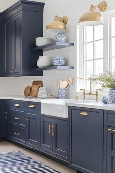 a blue and white kitchen with gold accents