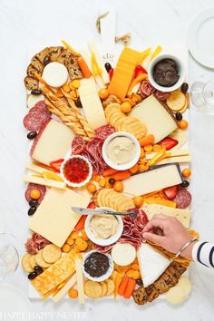 a platter with cheeses, crackers and sauces