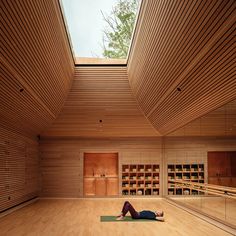 a person is laying on the floor in a room with wooden walls and ceilinging