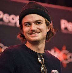 a man wearing a beanie and holding a microphone