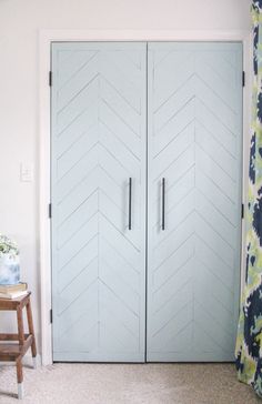 a room with two large blue doors and a chair in front of the closet door