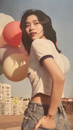 a woman standing in front of balloons with her hands on her hips and looking at the camera