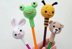 four crocheted animal pencils in the shape of animals with faces on them