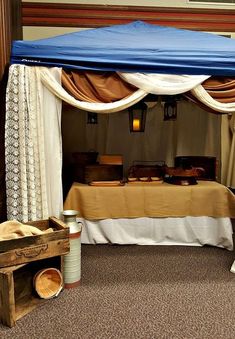 a bed with a blue canopy over it in a room filled with furniture and decor