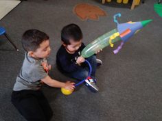 two young boys playing with toys on the floor